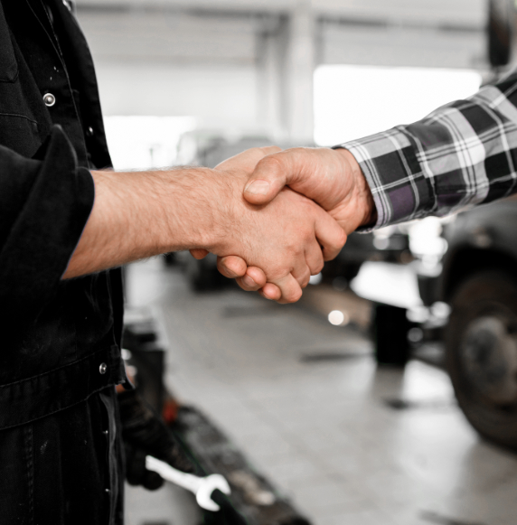 Handshake of technician of car repair service in workwear and one of clients
